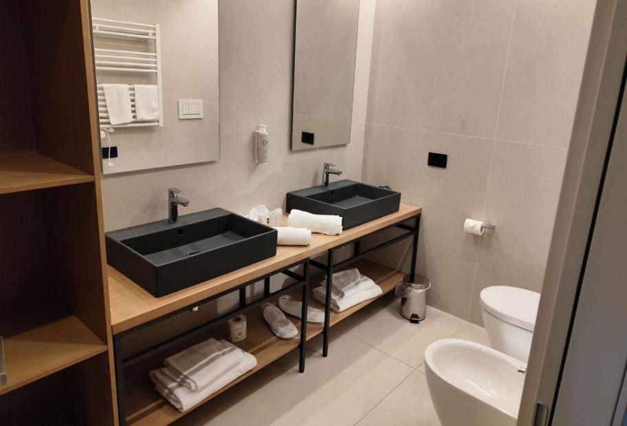 Bagno moderno con doppio lavabo, specchi e bidet.